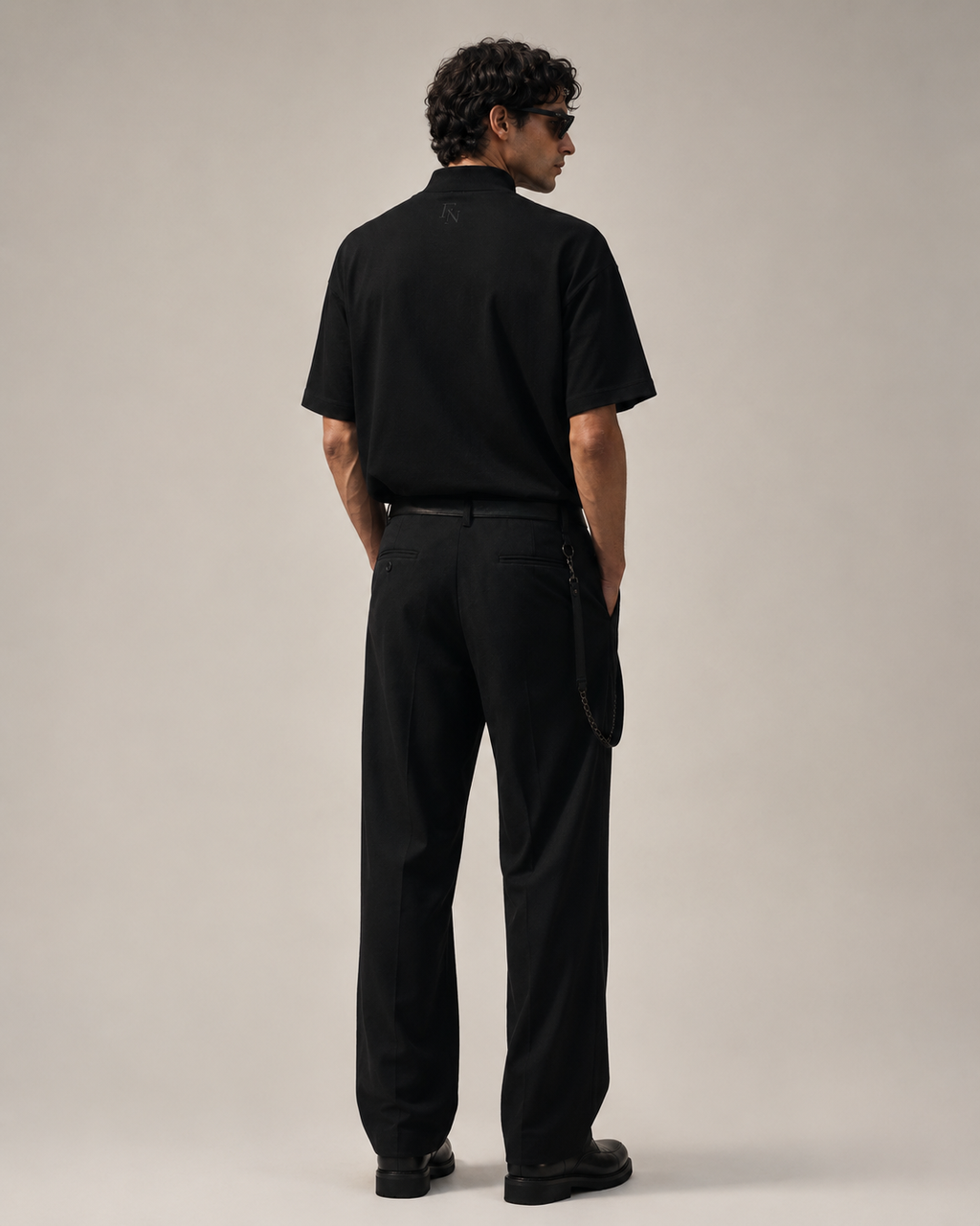 Modelo usando playera negra FVRZɅN FORM 01 de espalda